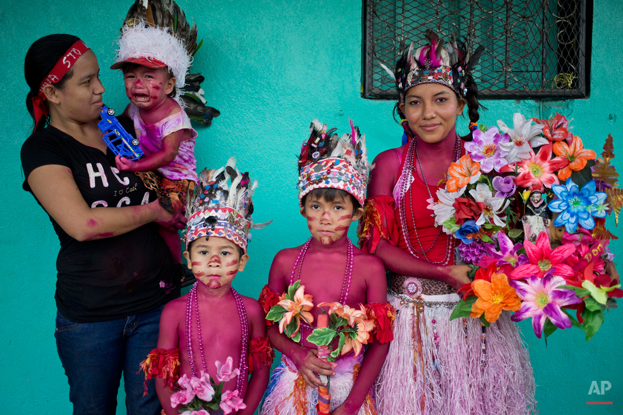  In this Aug. 10, 2015 photo, the Lopez family, with their  bodies covered with red paint, pose for a picture during a Managua's patron saint, Santo Domingo de Guzman's celebration, in Managua, Nicaragua. For more than 30 years the three generations 