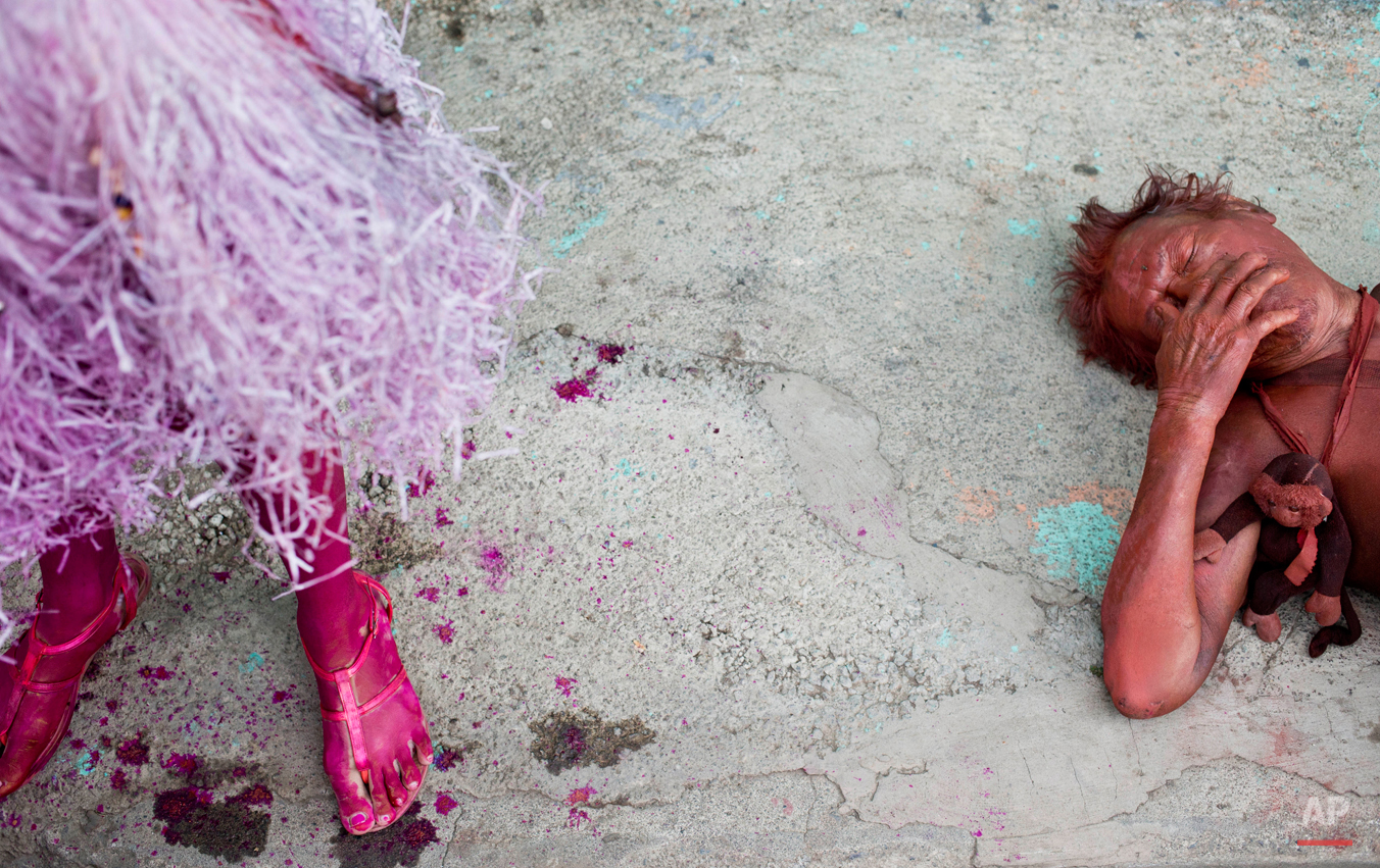  In this Aug. 10, 2015 photo, an intoxicated man lies on the street during Managua's patron saint, Santo Domingo de Guzman's celebration, in Managua, Nicaragua. During the 10 days of festivities revelers and devotees dance to live music and drink hug