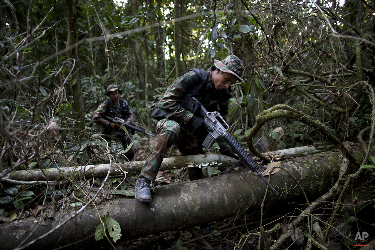  In this July 31, 2015 photo, counternarcotics special forces trek in the jungle after cratering a clandestine airstrip used by drug traffickers near Ciudad Constitucion, Peru. The airstrip can be repaired within a few days, sometimes less, depending