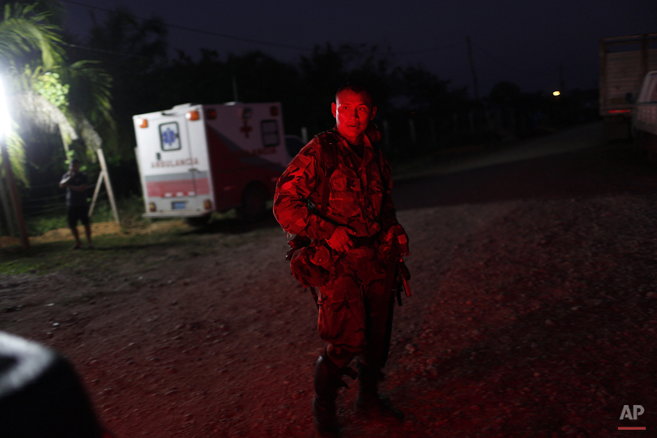  In this July 31, 2015 photo, a counternarcotics special forces police officer is illuminated by the lights of a pick-up truck at his base Ciudad Constitucion, Peru. He has just arrived from cratering a clandestine airstrip used by drug smugglers in 
