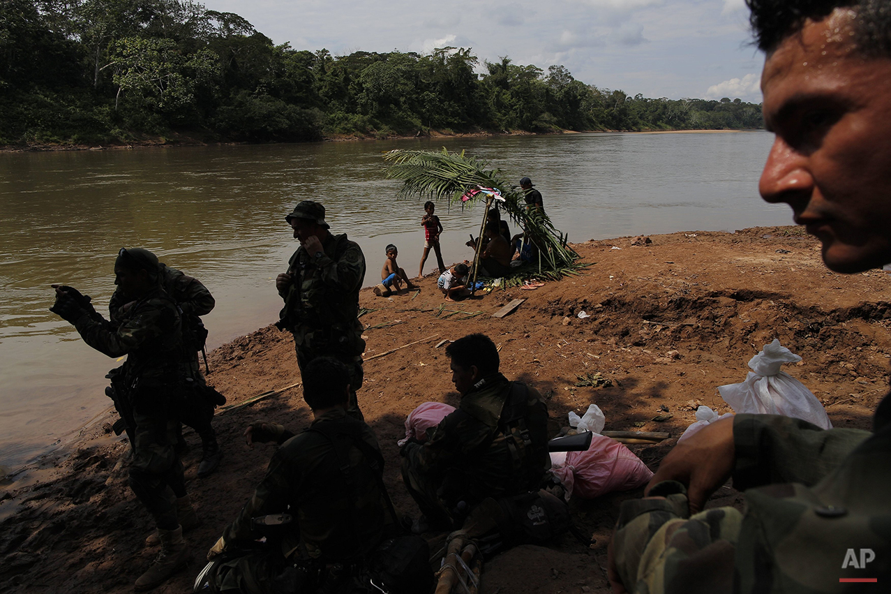  In this July 28, 2015 photo, a group of counternarcotics special forces wait for a boat to cross the Palcazu River as they head to crater a clandestine airstrip used by drug dealers near Ciudad Constitucion, Peru. On reaching the Palcazu River, they