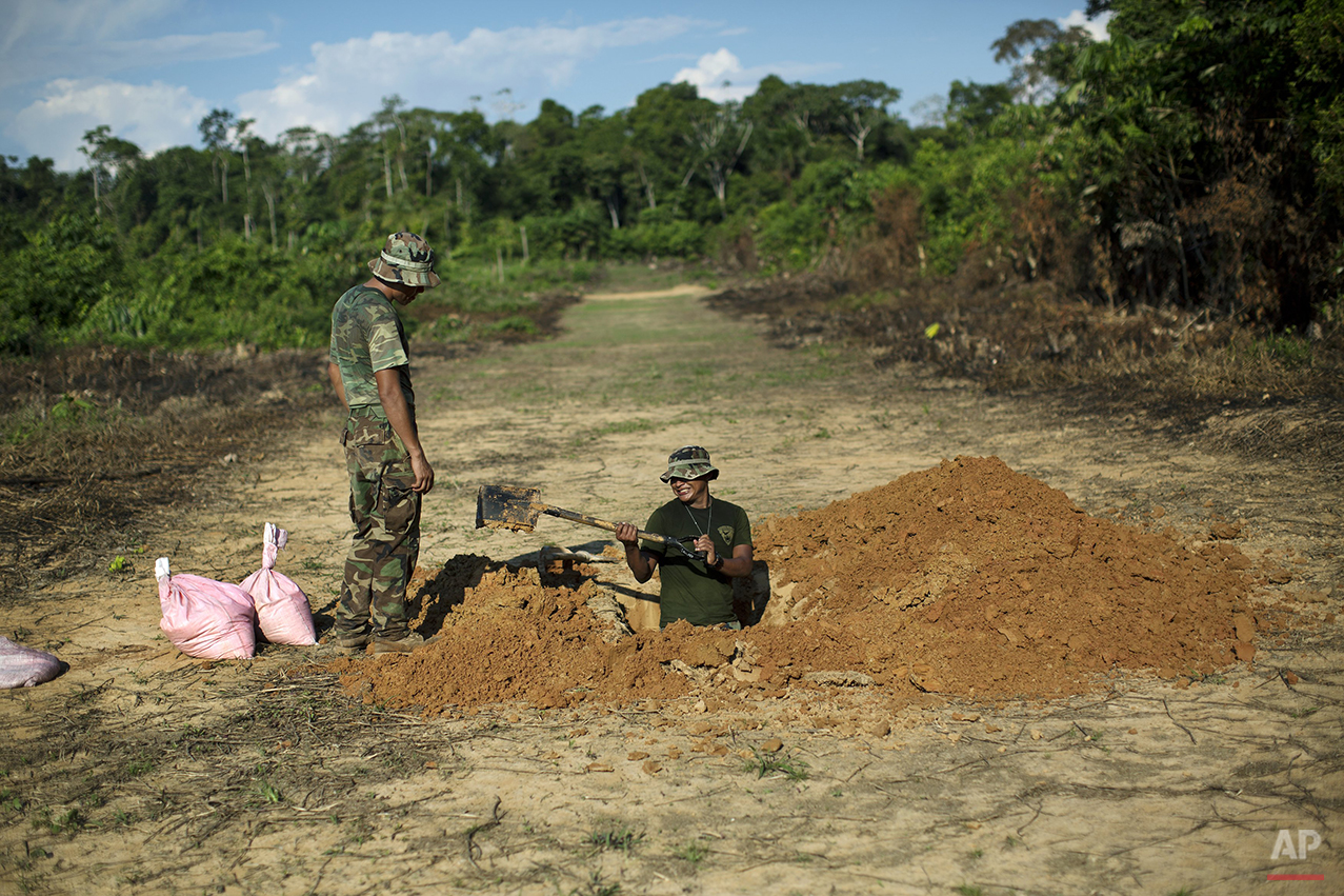  In this July 31, 2015 photo, counternarcotics special forces dig a ditch in a clandestine grassy airstrip used by drug traffickers in the jungle near Ciudad Constitucion, Peru. Explosives will be placed in the ditch to blow craters into the airstrip