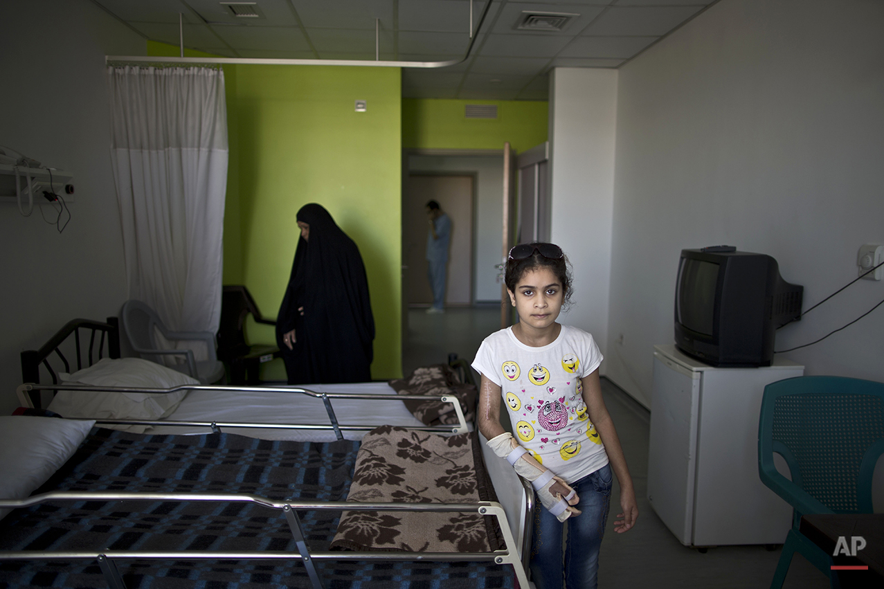  In this Tuesday, Aug. 11, 2015 photo, Iraqi girl Adyan Hazem, 11, who was injured in a car accident, poses for a picture at her room at MSF Hospital for Specialized Reconstructive Surgery in Amman, Jordan. The hospital, run by the international char