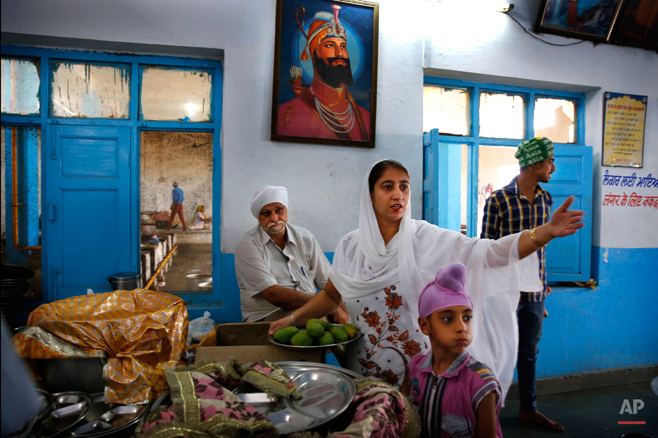  In this June 14, 2015 photo, volunteers and devotees help prepare langar at the Majnu-ka-Tilla Gurudwara or Sikh temple, in New Delhi, India. Langar, or the community meal, was started by Guru Nanak, who founded Sikhism in late 15th century, and is 