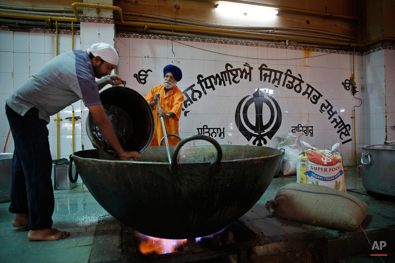  In this June 3, 2015, photo, Sikh devotees prepare langar, which translates to community dinner, at Bangla Sahib Gurudwara or Sikh temple, in New Delhi, India. Men, women and children throng the kitchen at Bangla Sahib, one of the biggest gurudwaras