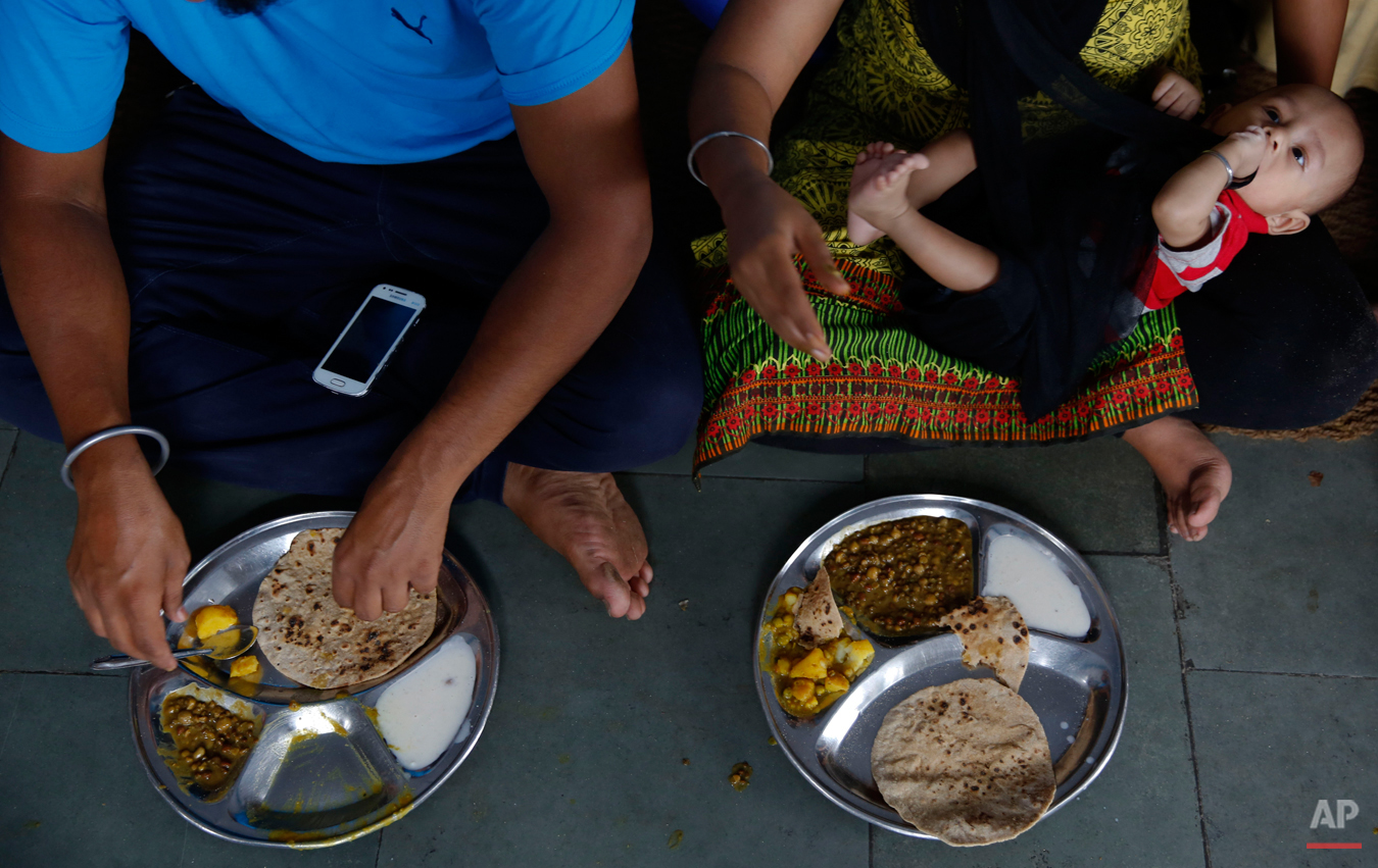  In this June 14, 2015 photo, a family eats langar at the Majnu-ka-Tilla Gurudwara or Sikh temple, in New Delhi, India. Langar, which translates to community dinner, was started by Guru Nanak, who founded Sikhism in late 15th century, and is now a tr