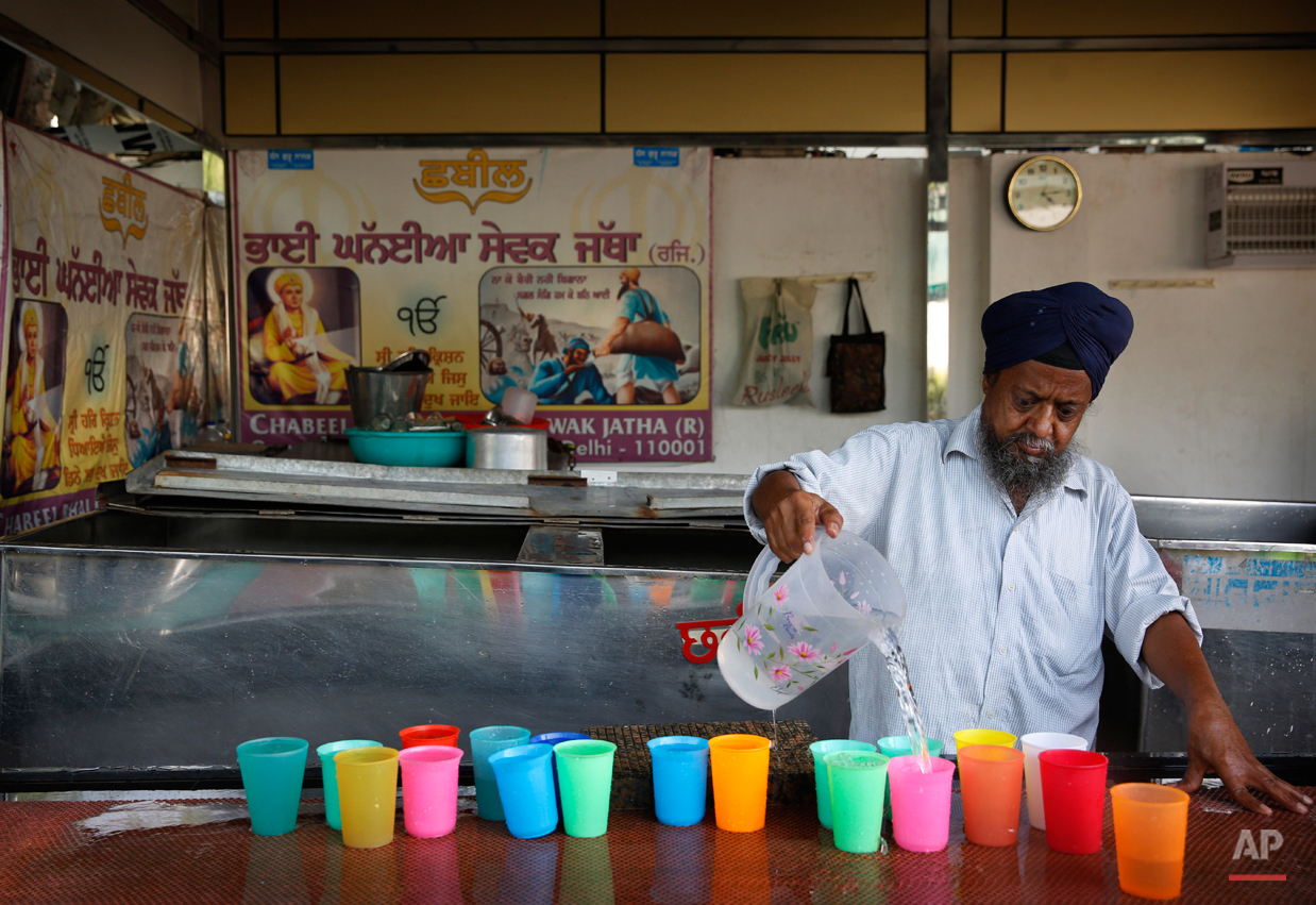  In this June 3, 2015, photo,  a Sikh devotee pours drinking water in glasses to be served during langar outside a hall at the Bangla Sahib Gurudwara or Sikh temple, in New Delhi, India. Service is one of the most integral traditions of gurudwaras. F
