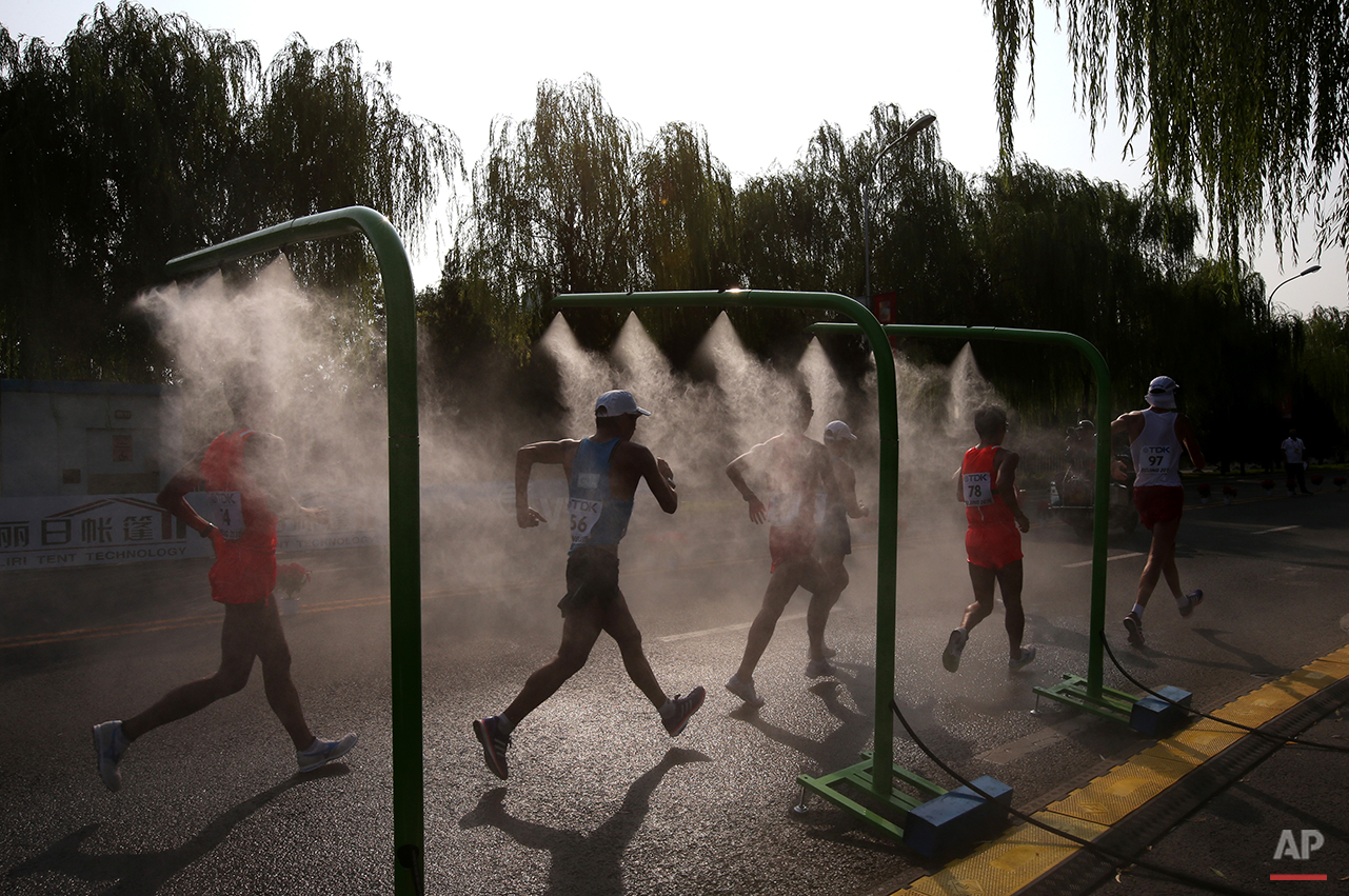  Competitors go through a cooling mist during the men's 50k race walk at the World Athletics Championships outside the Bird's Nest stadium in Beijing, Saturday, Aug. 29, 2015. (AP Photo/Kin Cheung) 