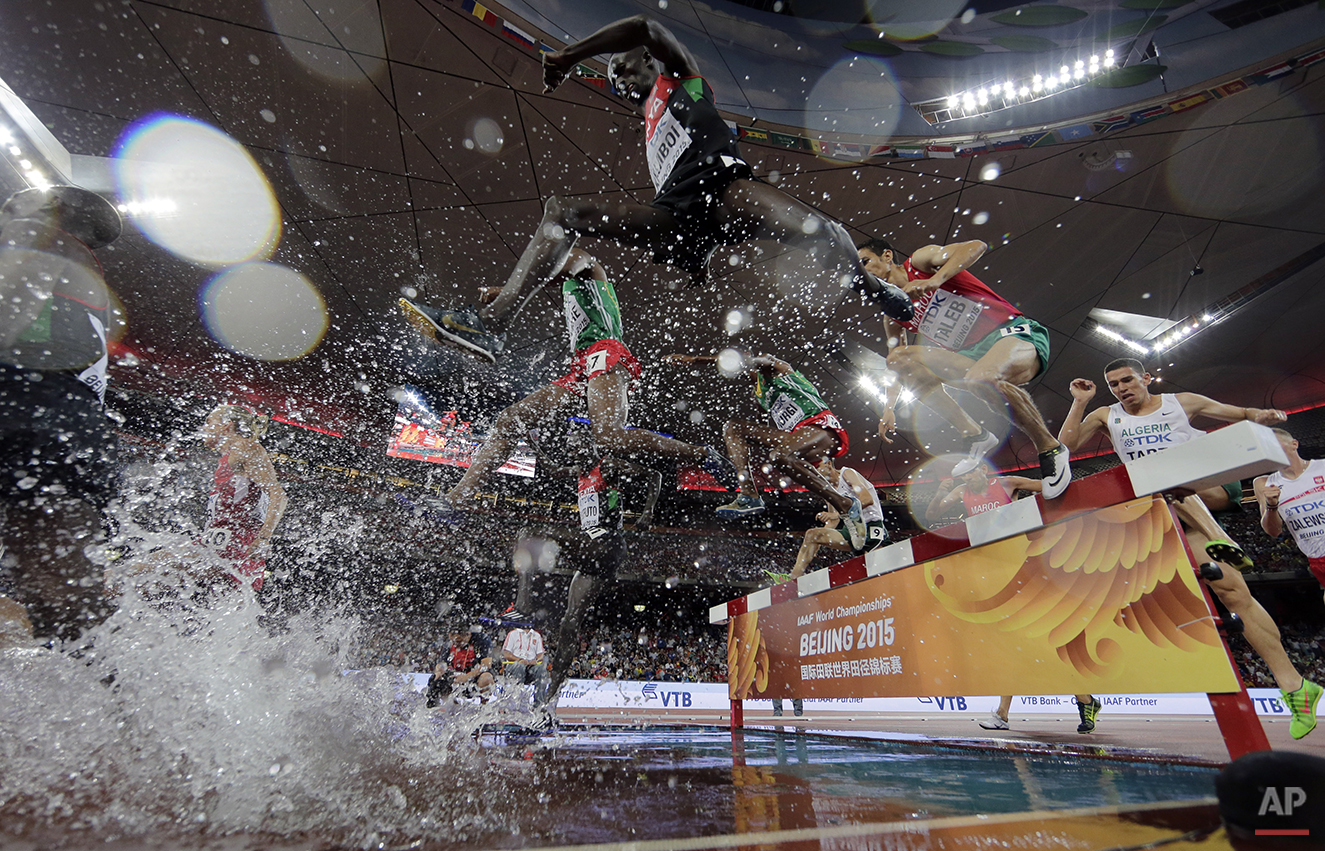  Kenya's Ezekiel Kemboi, centre, takes the water jump on his way to winning the gold medal in the men’s 3000m steeplechase final at the World Athletics Championships at the Bird's Nest stadium in Beijing, Monday, Aug. 24, 2015. (AP Photo/Andy Wong) 