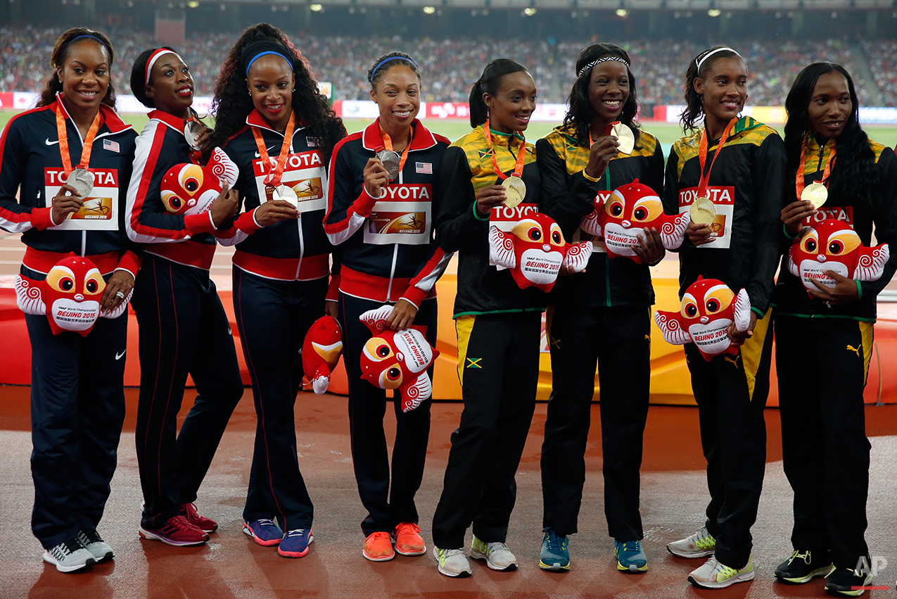  The teams of the United States, silver, left, and Jamaica, gold, pose with their medals during the ceremony for the women’s 4x400m relay  at the World Athletics Championships at the Bird's Nest stadium in Beijing, Sunday, Aug. 30, 2015. (AP Photo/Ng