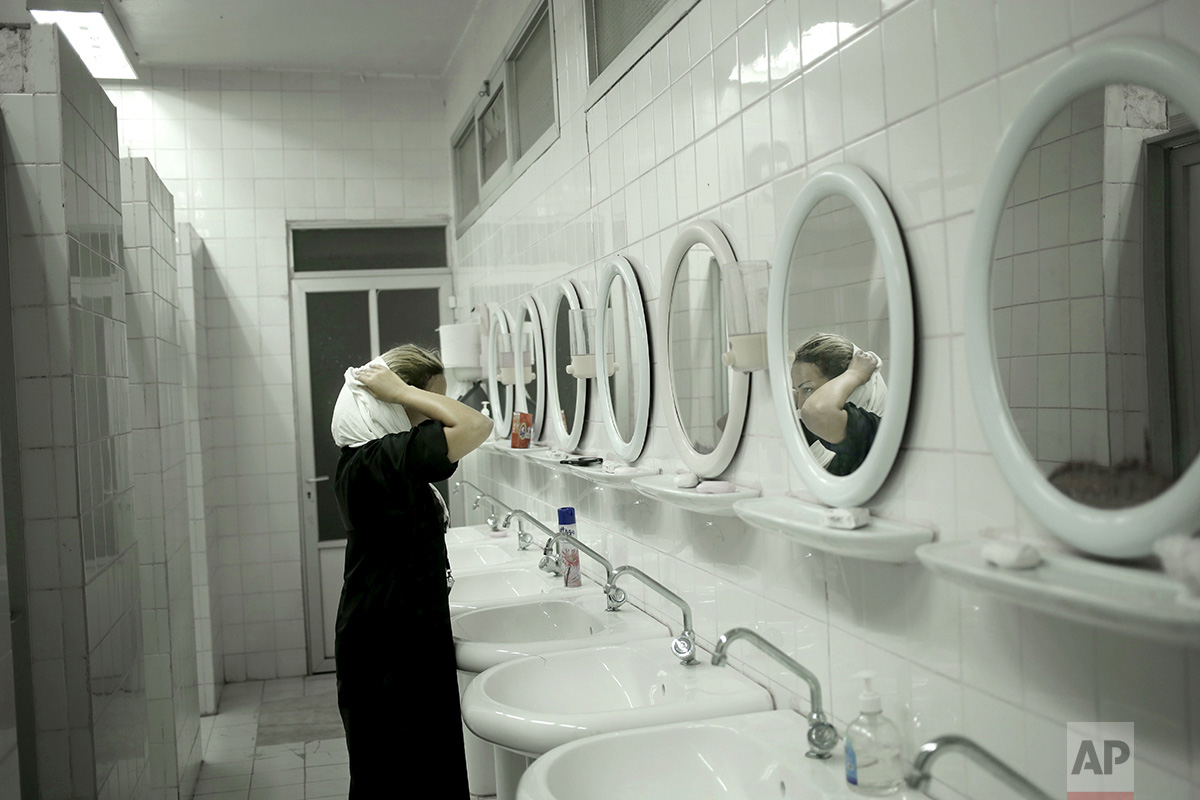  In this Tuesday, Sept. 13, 2016 photo, 36-year old Dalia from Lebanon takes off her hijab to start performing Wudu, a ritual of washing before prayer, inside an only women's camp in Mina, Saudi Arabia. "I am not convinced that hijab is a must and si