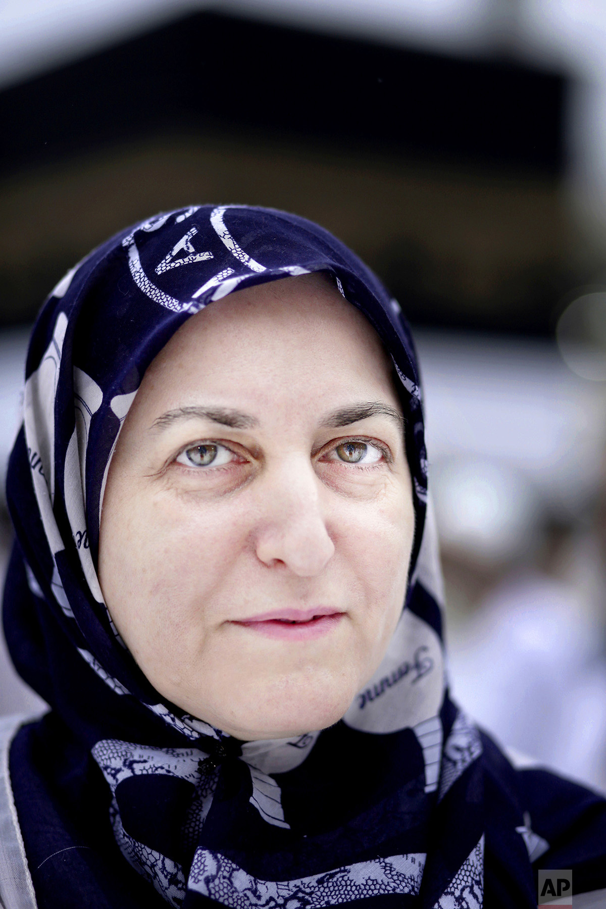  In this Thursday, Sept. 8, 2016 photo, Amria from Dagestan, Russia, poses for a photograph near the Kaaba, Islam's holiest site, at the Grand Mosque in the Muslim holy city of Mecca, Saudi Arabia. The annual hajj pilgrimage, required of able-bodied 