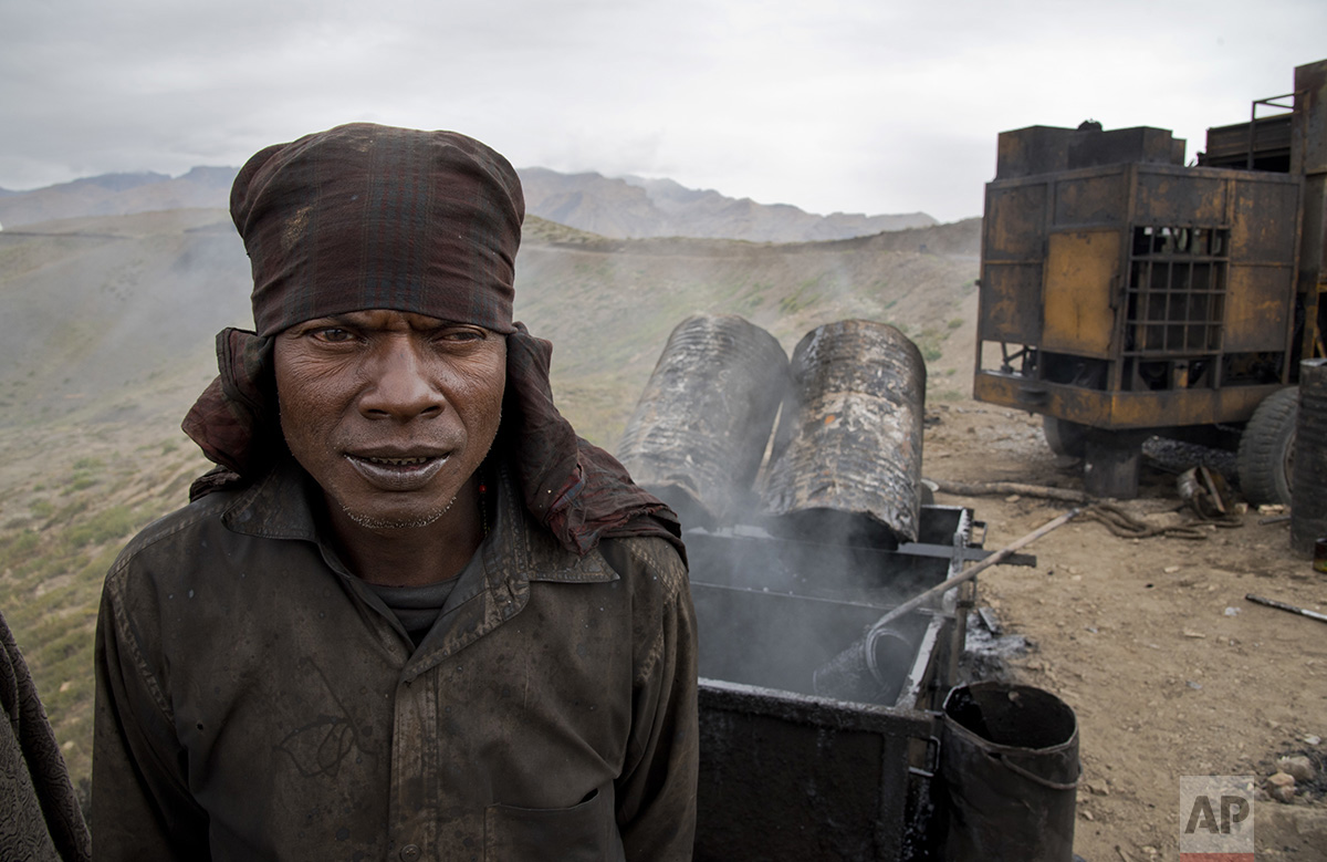  In this Aug. 17, 2016, photo, a worker stands next to a stove of liquid asphalt by a road under construction leading to Demul in Spiti Valley, India. (AP Photo/Thomas Cytrynowicz) 