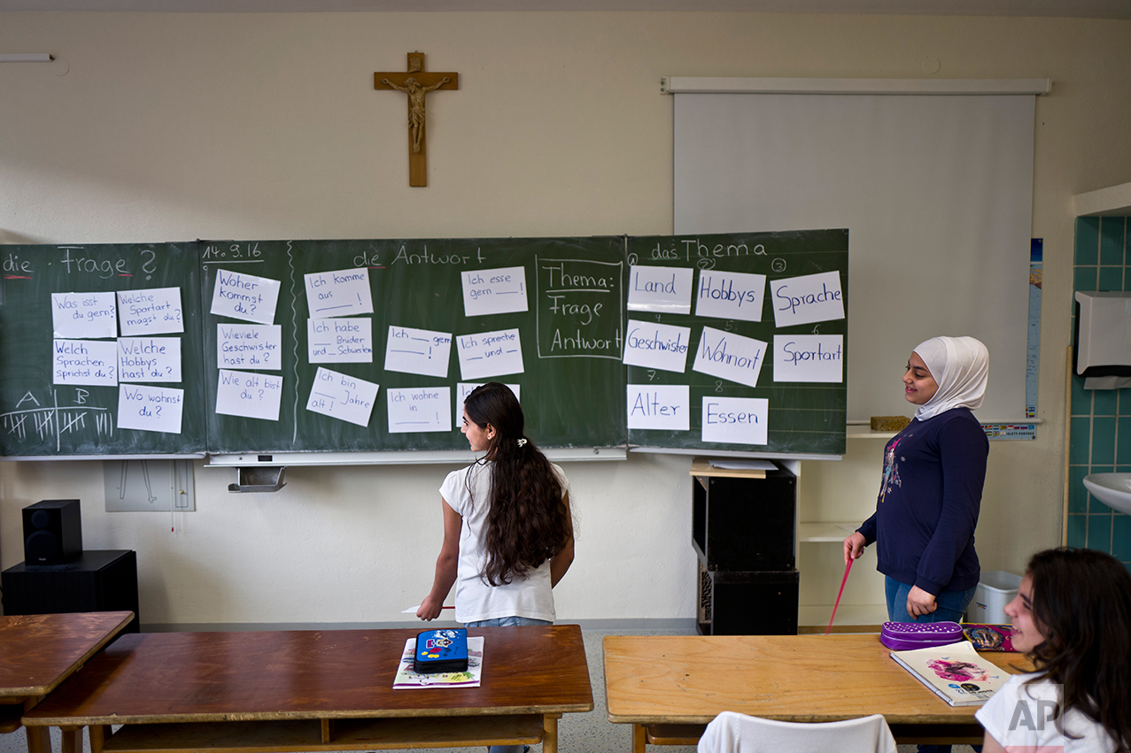  In this Thursday, Sept. 15, 2016 photo, Dunia  Qasu, 14, center, a Yazidi migrant from Sinjar, Iraq, attends a German language class at her school, Schulzentrum Oberes Elztal, in Oberwinden, Germany. (AP Photo/Muhammed Muheisen) 