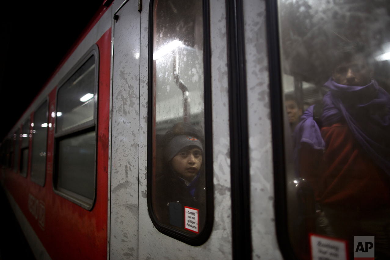  In this Tuesday, Dec. 8, 2015 photo, Dildar Qasu, 10, a Yazidi refugee from Sinjar, Iraq, leans on the door of the train as it arrives to  Mannheim, Germany, coming from Freilassing. (AP Photo/Muhammed Muheisen) 
