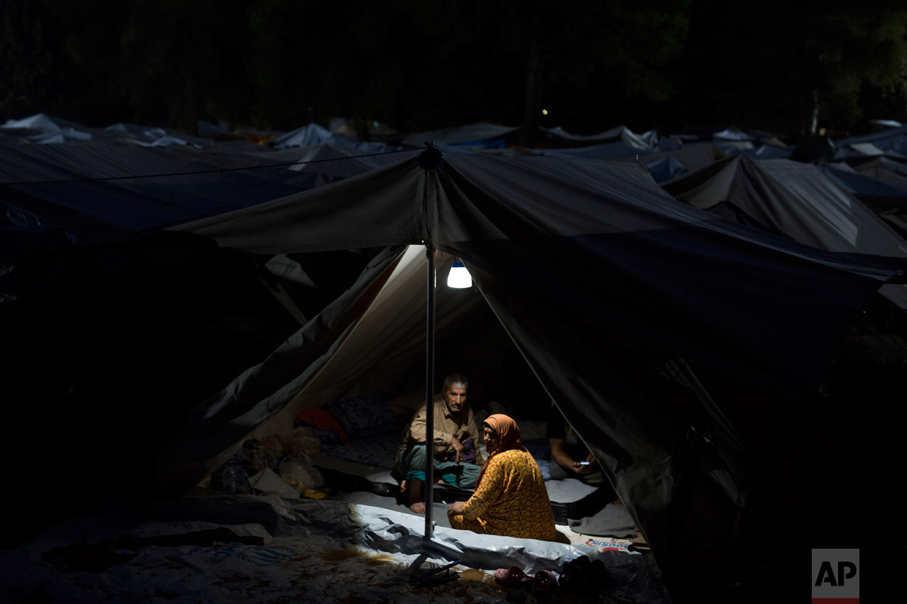  In this Thursday, Sept. 22, 2016 photo, a Syrian couple and visiting friends sit in their tent at the Ritsona camp for refugees and other migrants north of Athens. (AP Photo/Petros Giannakouris) 