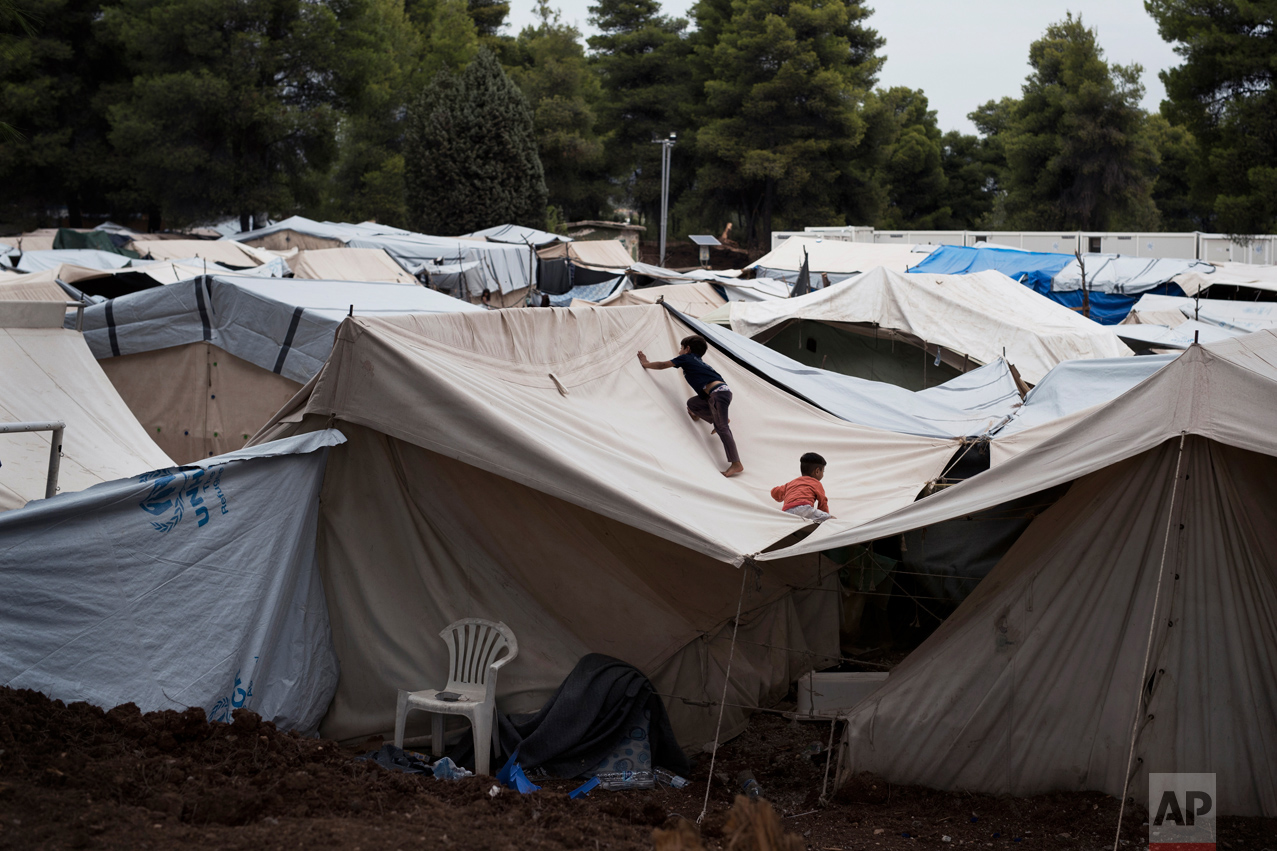  In this Thursday, Sept. 8, 2016 photo, Syrian children play on the top of a tent at the Ritsona camp for refugees and other migrants north of Athens. Like dozens of refugee camps hastily created around Greece, Ritsona started with tents set up in an