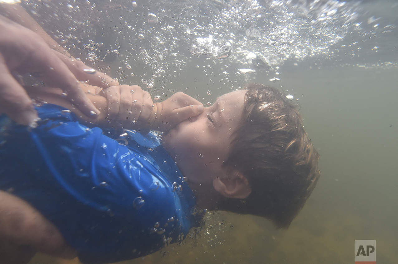  Garrett Dorsey, 8, is baptized in the Chattahoochee River, Sunday, Sept. 18, 2016, near Demorest, Ga. The ancient sacrament is memorialized in the gospel account of John the Baptist immersing Jesus in the Jordan River. (AP Photo/Mike Stewart) 