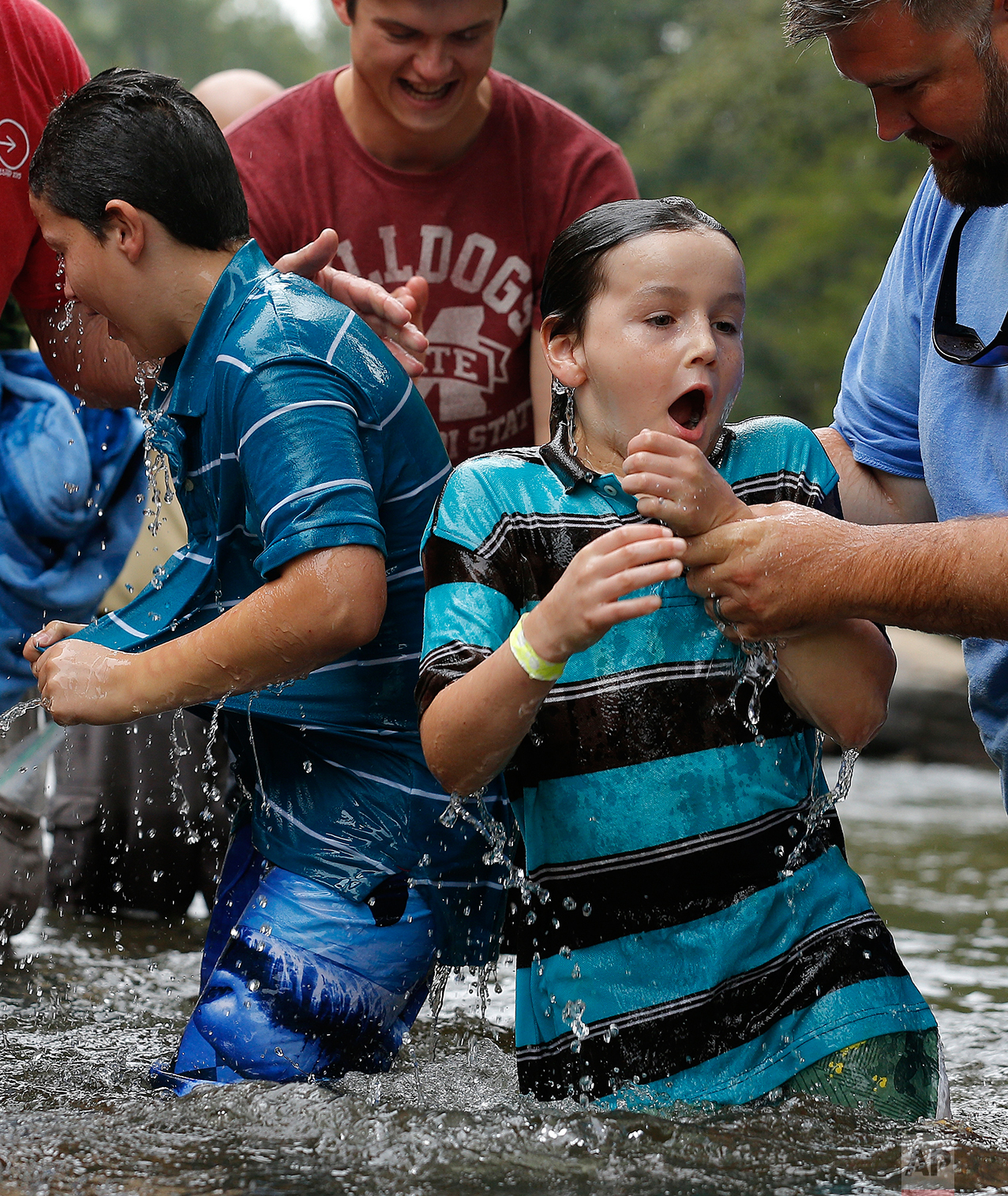  Brothers Will, 10, left, and Bowe Roberts, 9, react after being baptized in the Chattahoochee River, Sunday, Sept. 18, 2016, near Demorest, Ga. The ancient sacrament is memorialized in the Gospel account of John baptizing Jesus in the Jordan River. 