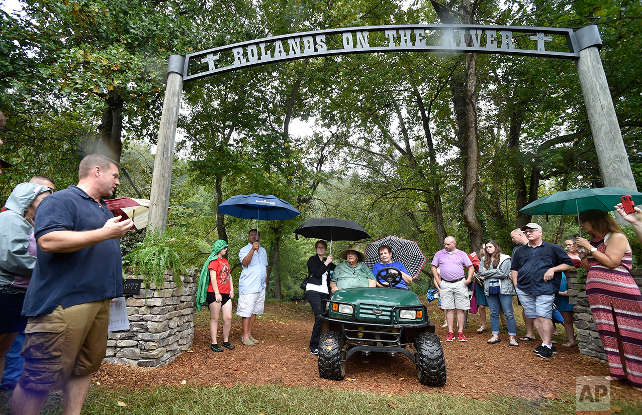  Lead Pastor Kevin Mangum, left, speaks to a large group as the River Point Community Church dedicate a "Rolands on the River," sign to Sidney Roland Jr., in vehicle with his wife, Suzanne, near the Chattahoochee River, Sunday, Sept. 18, 2016, near D