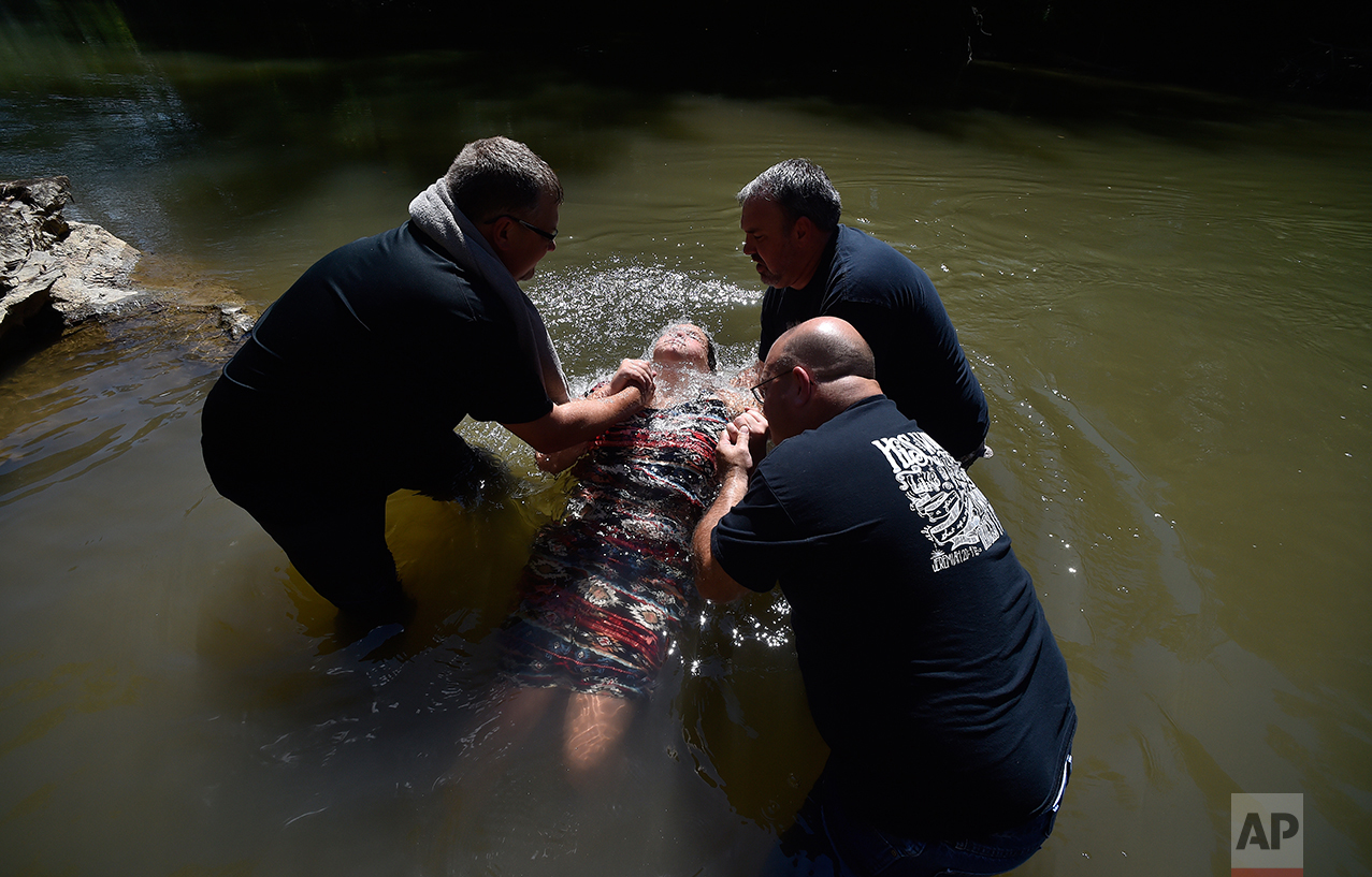  Resaca Church Of God Pastor Mitchell Gaston, left,  with Clint Cooper and David Vowell baptize Ellie Langford, 12, in the Coosawattee river, Sunday, Sept. 25, 2016, near Calhoun, Ga. Ciara Langford, whose two daughters were baptized, said, "I felt i