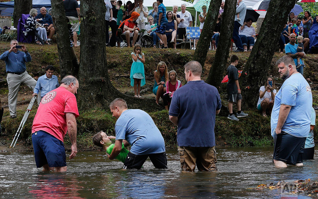  Jamie Spinks baptizes his son, Grayson, 8, in the Chattahoochee River, Sunday, Sept. 18, 2016, near Demorest, Ga. Children from age 7 and adults into their 70s are baptized by pastors or family. (AP Photo/Mike Stewart) 