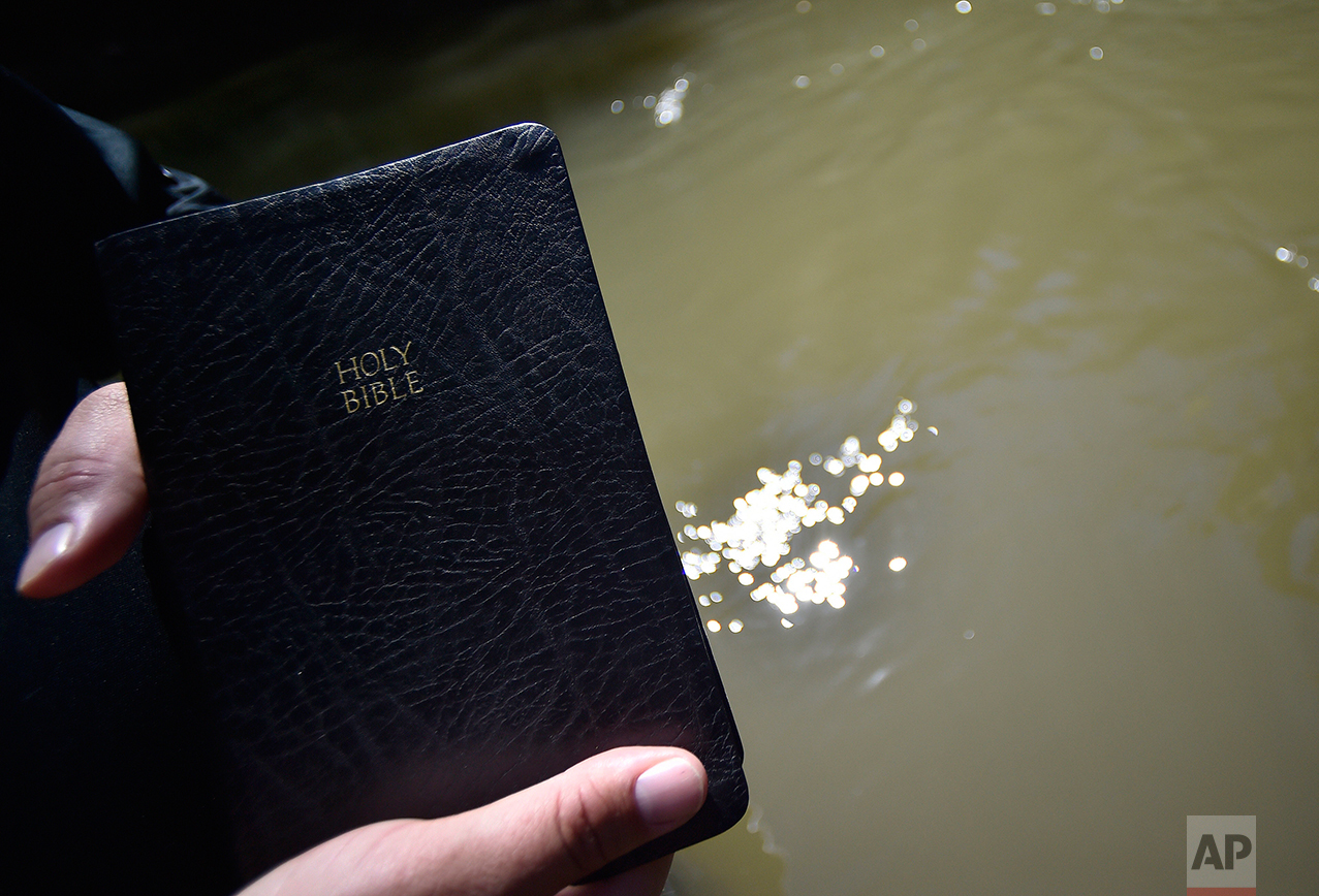  Resaca Church Of God Pastor Mitchell Gaston holds a bible as he prays before congregants are baptized in the Coosawattee river, Sunday, Sept. 25, 2016, near Calhoun, Ga. Many denominations don’t fully immerse baptismal candidates, preferring to spri