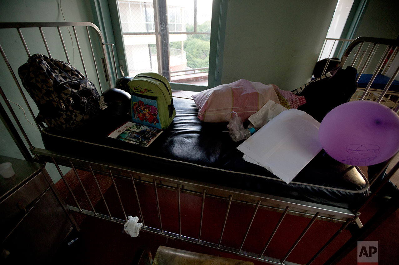 In this Sept. 19, 2016 photo, the packed belongings of Ashley Pacheco sit on top of her bed, as she waits to be discharged from University Hospital in Caracas, Venezuela. Two months after the 3-year-old was first admitted with a staph infection in her left leg, the doctor declared Ashley infection-free. Her mother sold the medication the family had left over to other mothers on the floor, putting away some of that money for future treatment. “I could have sold the medicine for four times as much as I did, it's so precious.” said Pacheco. (AP Photo/Fernando Llano)