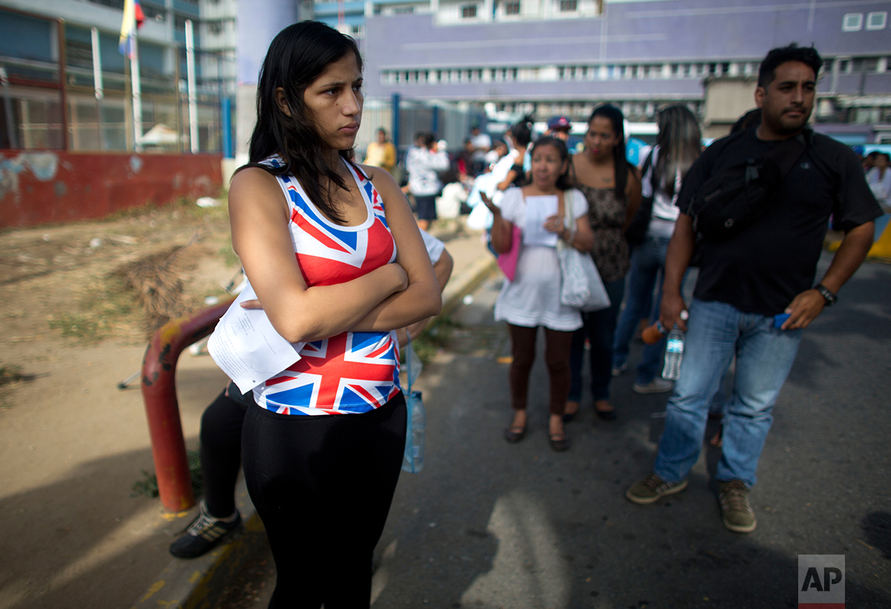 In this Aug. 25, 2016 photo, Oriana Pacheco stands in line to get an appointment for an ultrasound test for her daughter at one of the few public hospitals with a functioning machine, in Caracas, Venezuela. Doctors would not discharge her 3-year-old daughter until she had the test. When Oriana reached the front of the line, the clerk told her the first slot was in November, two months away. (AP Photo/Ariana Cubillos)