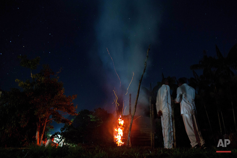  In this June 22, 2016 photo, church members of the doctrine of the Holy Daime warm themselves next to a bonfire during a break in the service in Ceu do Mapia, Amazonas state, Brazil. The community revolves around an ancient psychedelic tea locals kn
