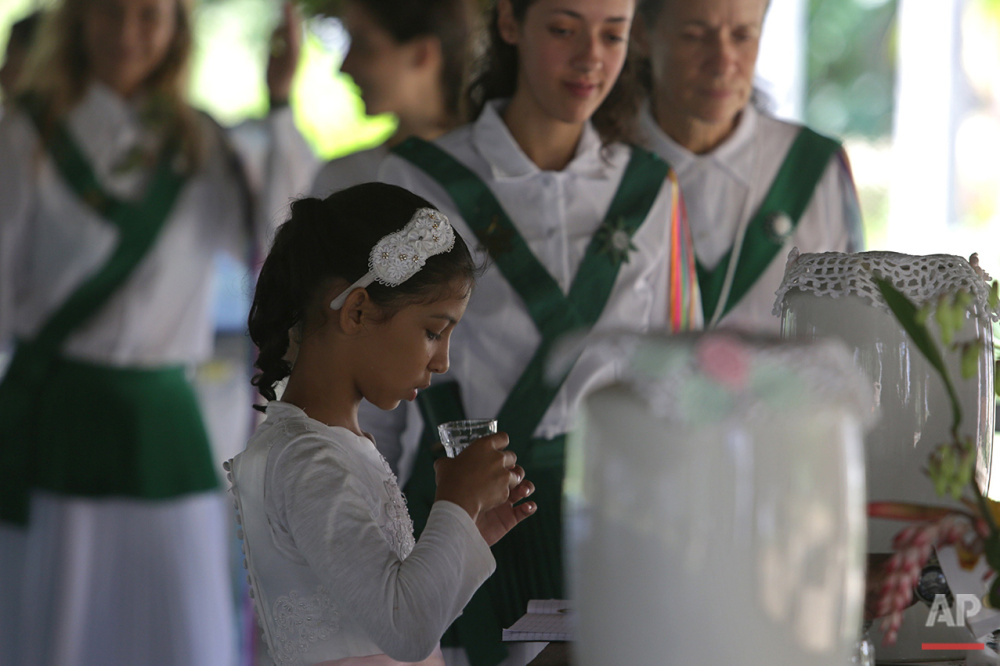  In this June 22, 2016 photo, 9-year-old Natalia Catarina takes part in the consecration of the Holy Daime during a religious service at the church of Ceu do Mapia, in Amazonas state, Brazil. All members of the community, including children, consume 