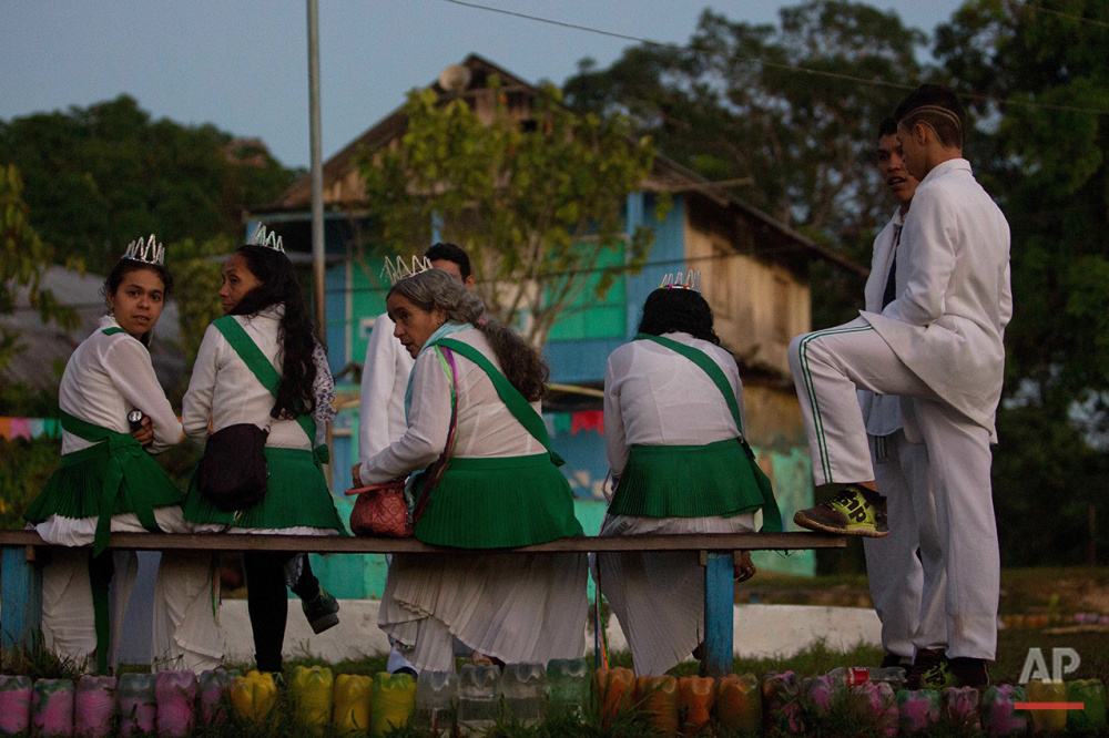  In this June 22, 2016 photo, members of the community mill around the local temple before partaking in the ritual Holy Daime in Ceu do Mapia, Amazonas state, Brazil. During the service men and women lined up in two separate rows to drink the psyched