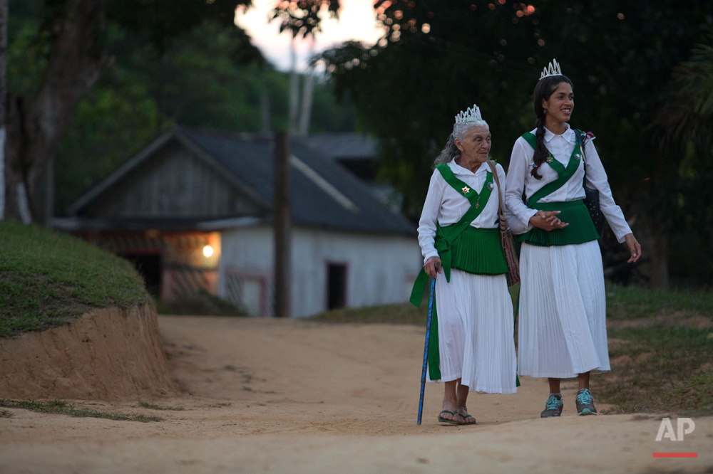  In this June 22, 2016 photo, 83-year-old Godmother Julia Chagas, left, walks supported by her granddaughter to attend the ritual of the Holy Daime in Ceu do Mapia, Amazonas state, Brazil. Chagas is the widow of rubber tapper Sebastiao Mota de Melo, 