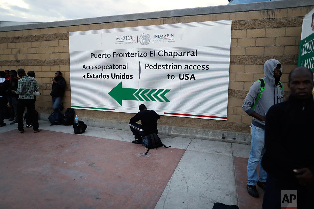 n this Sept. 27, 2016 photo, Haitian migrants wait at the border crossing in Tijuana, Mexico. Mexican officials distribute paper slips with dates to appear at San Ysidro on the U.S. side of the border. (AP Photo/Gregory Bull)