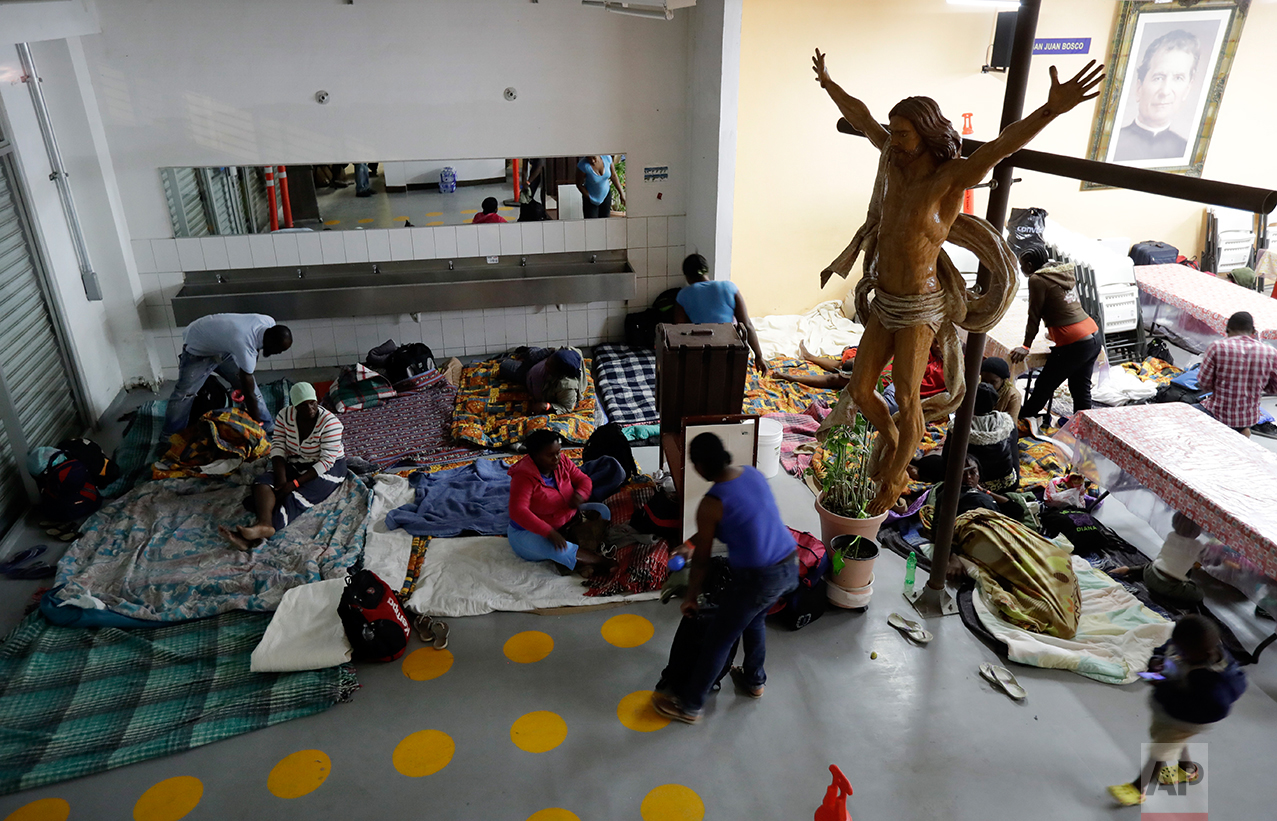 In this Oct. 3, 2016 photo, Haitian women and children get ready to sleep on the floor of the Padre Chava migrant shelter in Tijuana, Mexico. Hundreds, perhaps thousands, of Haitian men, women and children regularly spend the night just outside the busiest U.S. border crossing. (AP Photo/Gregory Bull)