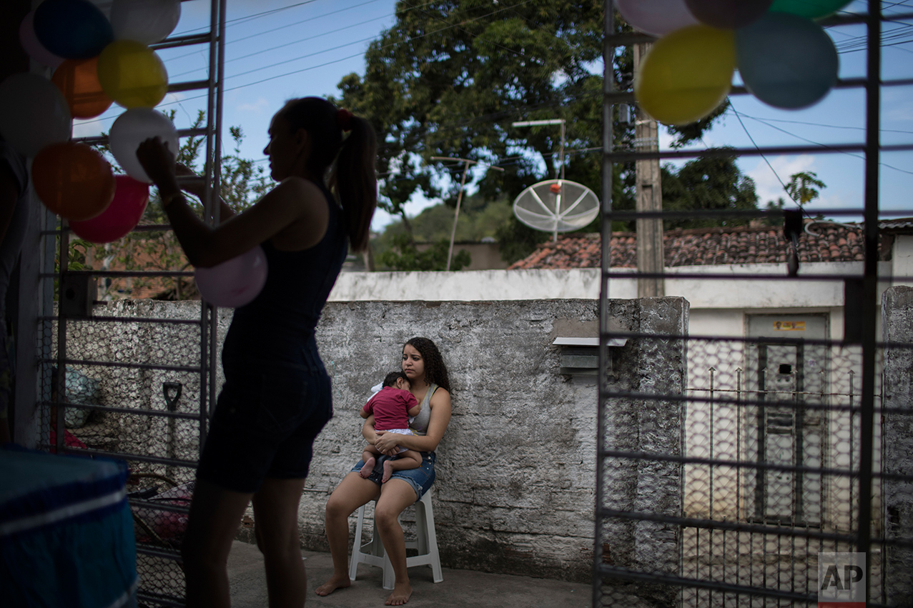 In this Oct. 1, 2016 photo, Tatiane holds her nephew Arthur Conceicao, who was born with microcephaly, during his one-year birthday party in Recife, Pernambuco state, Brazil. Health Minister Ricardo Barros said there was a drop of 85 percent in microcephaly cases in August and September compared to those months last year, when the first births started worrying pediatricians. He credited growing awareness of the virus and government attempts to combat mosquitoes through spraying campaigns. (AP Photo/Felipe Dana)