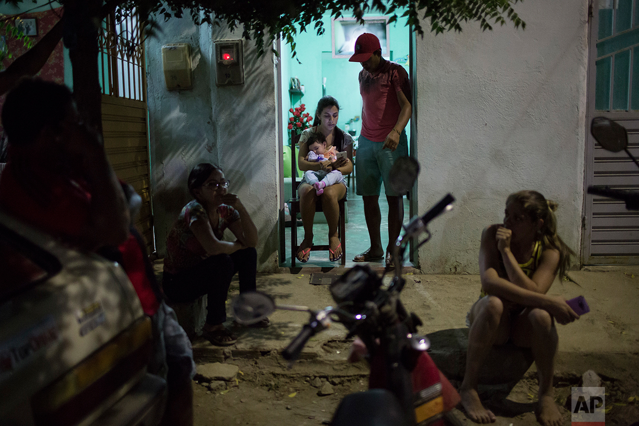 In this Sept. 26, 2016 photo, Angelica Pereira holds her daughter Luiza, who was born with microcephaly, as her husband Dejailson Arruda stands by at their home in Santa Cruz do Capibaribe, Pernambuco state, Brazil. Pereira says it’s a victory just for her daughter Luiza to reach her first birthday. Despite Luiza’s suffering from daily seizures and breathing problems, Pereira is hopeful her health and motor skills will improve with time. (AP Photo/Felipe Dana)