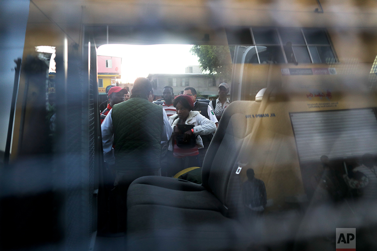 In this Oct. 3, 2016 photo, Mexican immigration officials load a group of Haitians into a van, to help them find shelter, in Tijuana, Mexico. Rosario Lozada, the city’s director of migrant affairs, was exasperated after the latest arrivals raised her estimate of Haitians stuck in Tijuana to 2,000, half of them in shelters and the rest in hotels or on the streets. (AP Photo/Gregory Bull)