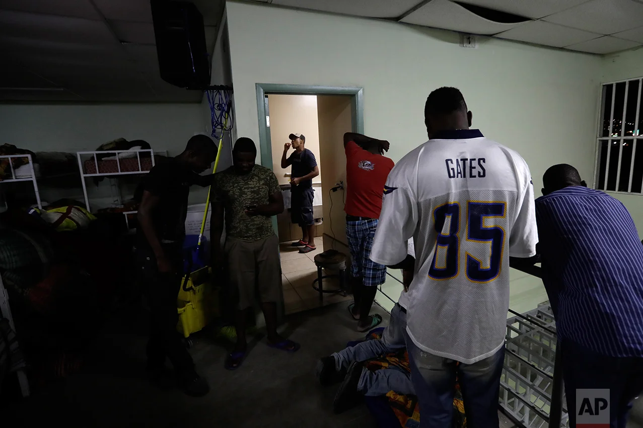 In this Sept. 26, 2016 photo, Haitian migrants prepare for their stay at the Padre Chava migrant shelter, in Tijuana, Mexico. Padre Chava, one of 10 Tijuana shelters that house Haitians, turned away hundreds over the weekend, leading many to sleep outside on cardboard sheets. (AP Photo/Gregory Bull)