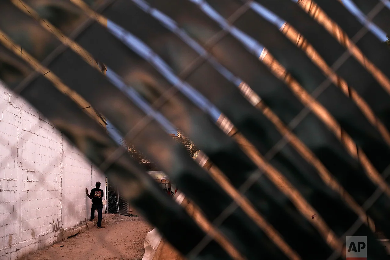 In this Sept. 26, 2016 photo, a Haitian migrant waits along a wall at the Padre Chava migrant shelter as diner is served inside, in Tijuana, Mexico. U.S. officials say about 5,000 Haitians showed up at San Ysidro from October 2015 through late last month. (AP Photo/Gregory Bull)