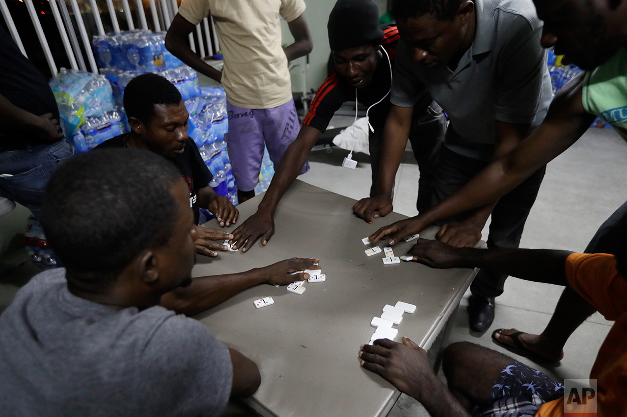 In this Sept. 26, 2016 photo, Haitian migrants play dominoes at the Padre Chava migrant shelter, in Tijuana, Mexico. “We are exhausted, completely exhausted,” said shelter administrator Margarita Andonaegui. “When we have more than 200 people, we lose control.” (AP Photo/Gregory Bull)