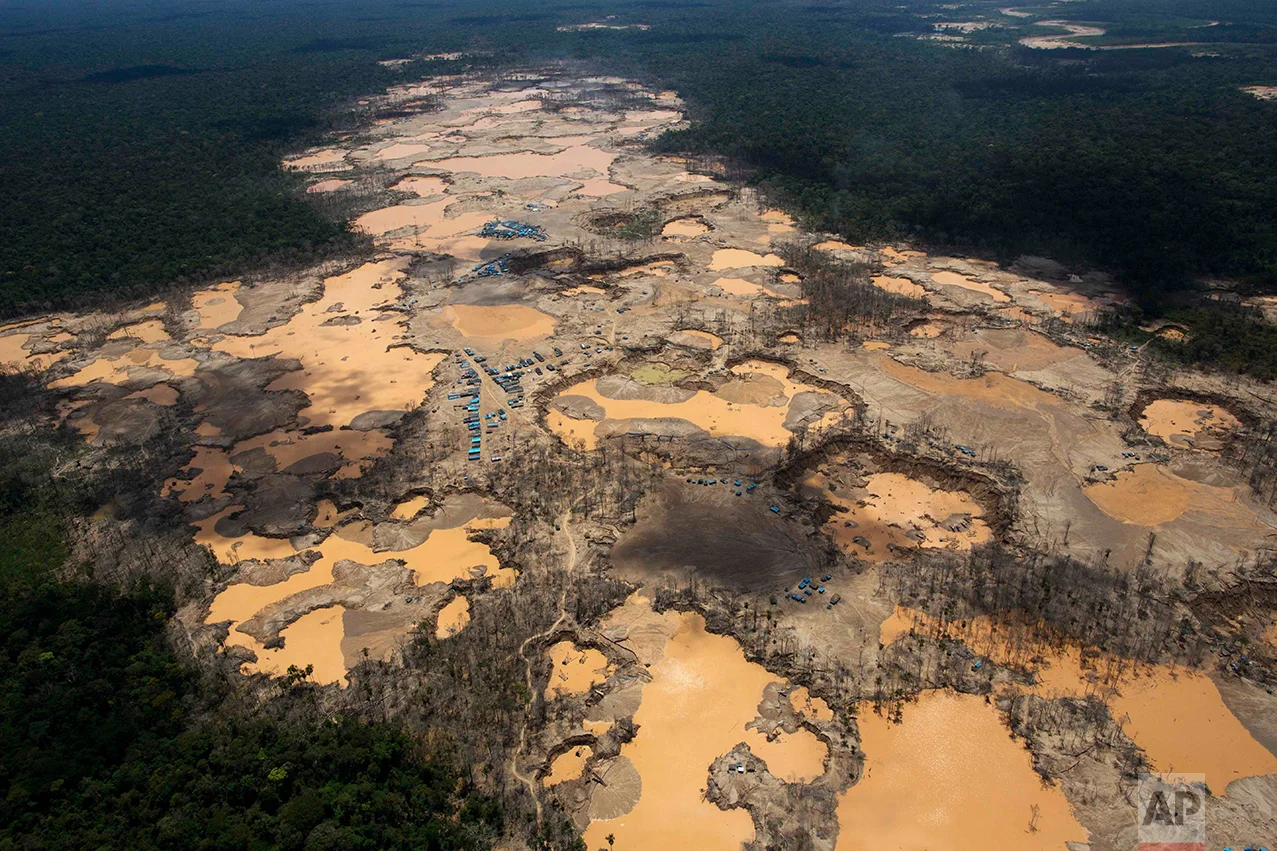This Nov. 11, 2014 photo shows a deforested area dotted with blue tarps, marking the area where miners reside, and craters filled with water, caused by illegal gold mining activities, in La Pampa, in Peru's Madre de Dios region. Peru's government declared an emergency across a broad jungle region because of mercury contamination, much of it caused by wildcat gold mining. (AP Photo/Rodrigo Abd)