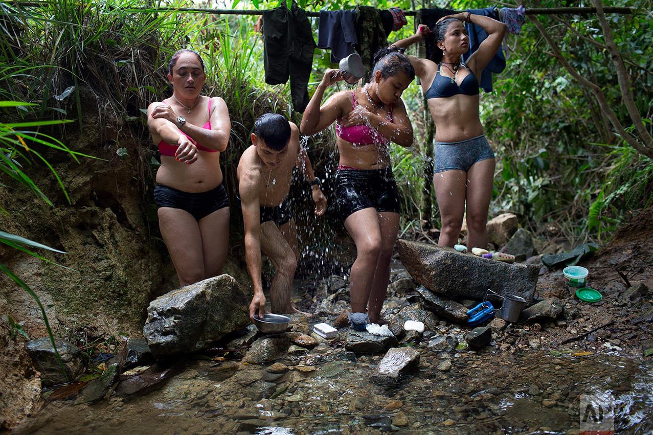 In this Jan. 4, 2016 photo, rebel fighters for the 36th Front of the Revolutionary Armed Forces of Colombia, or FARC, bathe in a creek near their hidden camp in Antioquia state, in the northwest Andes of Colombia. The rebel fighters share all facilities on equal terms. Many of them are couples and share sleeping quarters. (AP Photo/Rodrigo Abd)