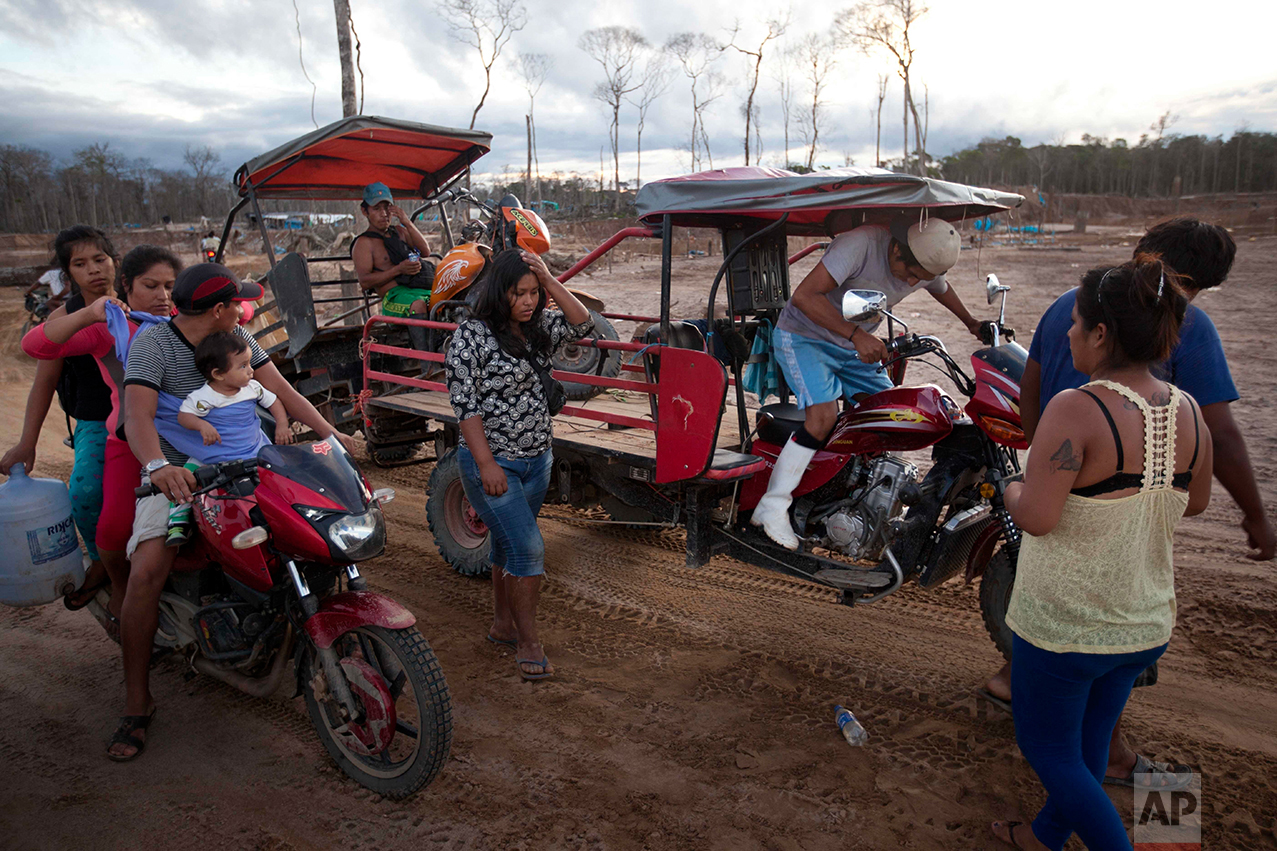 In this May 16, 2014 photo, miners leave the site where they lived and worked after police destroyed their illegal mining operation in La Pampa in the Madre de Dios region of Peru, Friday, May 16, 2014. Madre de Dios state has an estimated 40,000 illegal miners, most of whom are poor migrants from the Andean highlands. (AP Photo/Rodrigo Abd)