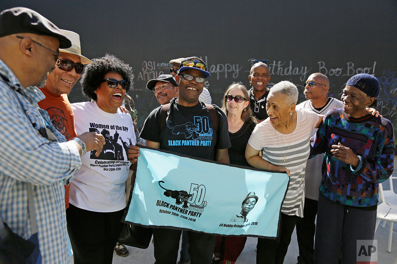 In this photo taken Saturday, Oct. 8, 2016, former members of the Black Panther Party laugh and visit outside a museum after an anniversary meeting in Oakland, Calif. In the front row is Billy X. Jennings, center, M. Gayle Asali-Dickson, second from right and Lorene Johnson, right. (AP Photo/Eric Risberg)