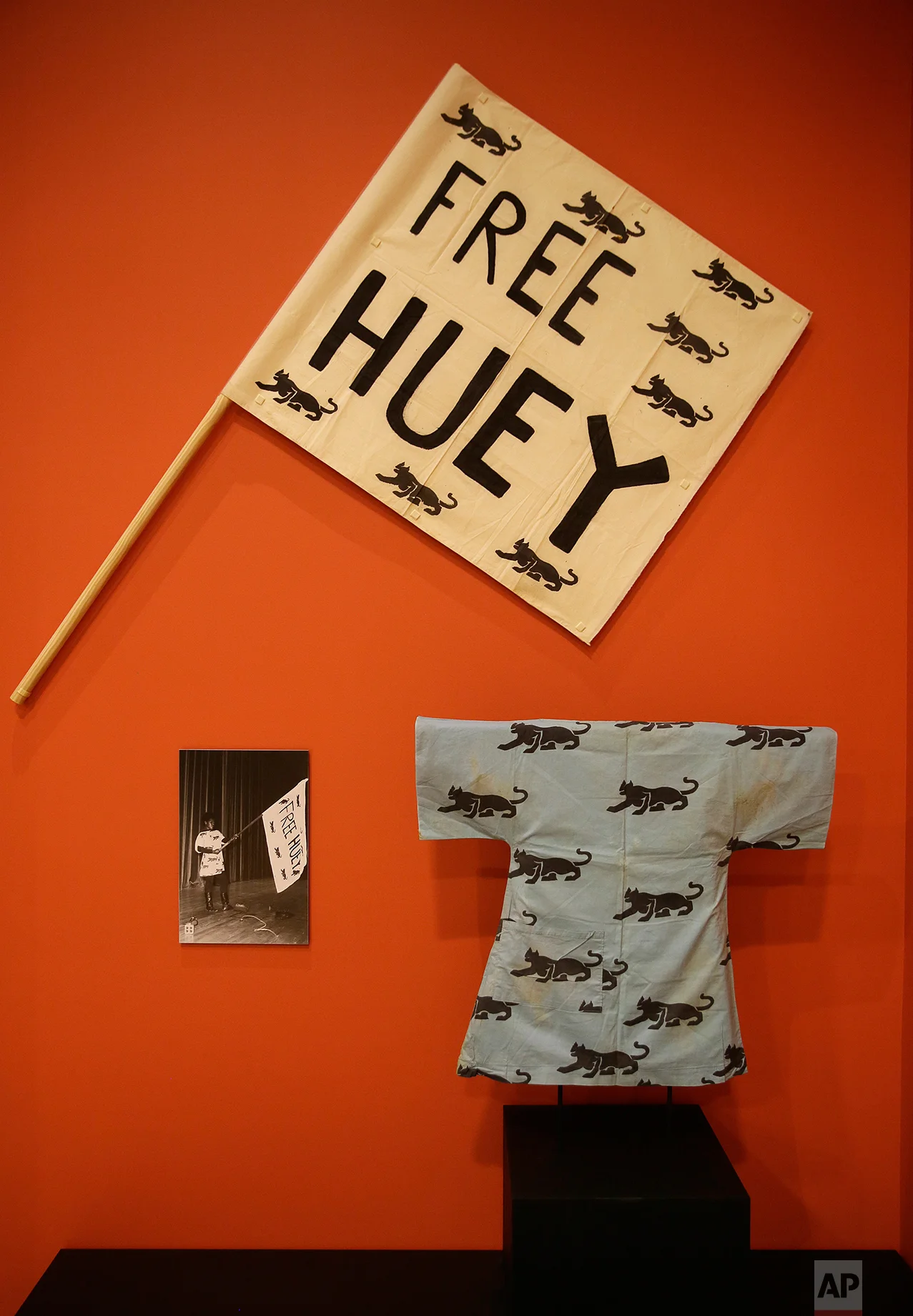 In this photo taken Monday, Oct. 3, 2016, a silkscreen on fabric flag urging the release of Huey Newton and a patterned dress are displayed in the exhibition called "All Power to the People: Black Panthers at 50" at the Oakland Museum of California in Oakland, Calif. (AP Photo/Eric Risberg)