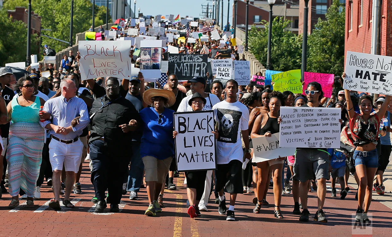 In this Sunday, July 10, 2016 photo, people march in a Black Lives Matter rally in Oklahoma City. (AP Photo/Sue Ogrocki)