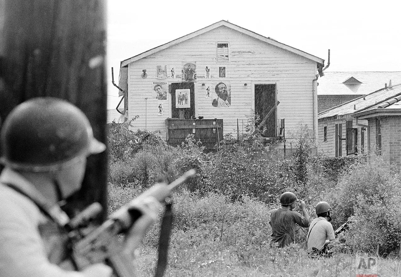 New Orleans policemen take cover as they move in on Black Panther headquarters in New Orleans following a shootout, Sept. 15, 1970. Shooting erupted as police moved in to make arrests. (AP Photo/Jack Thornell)