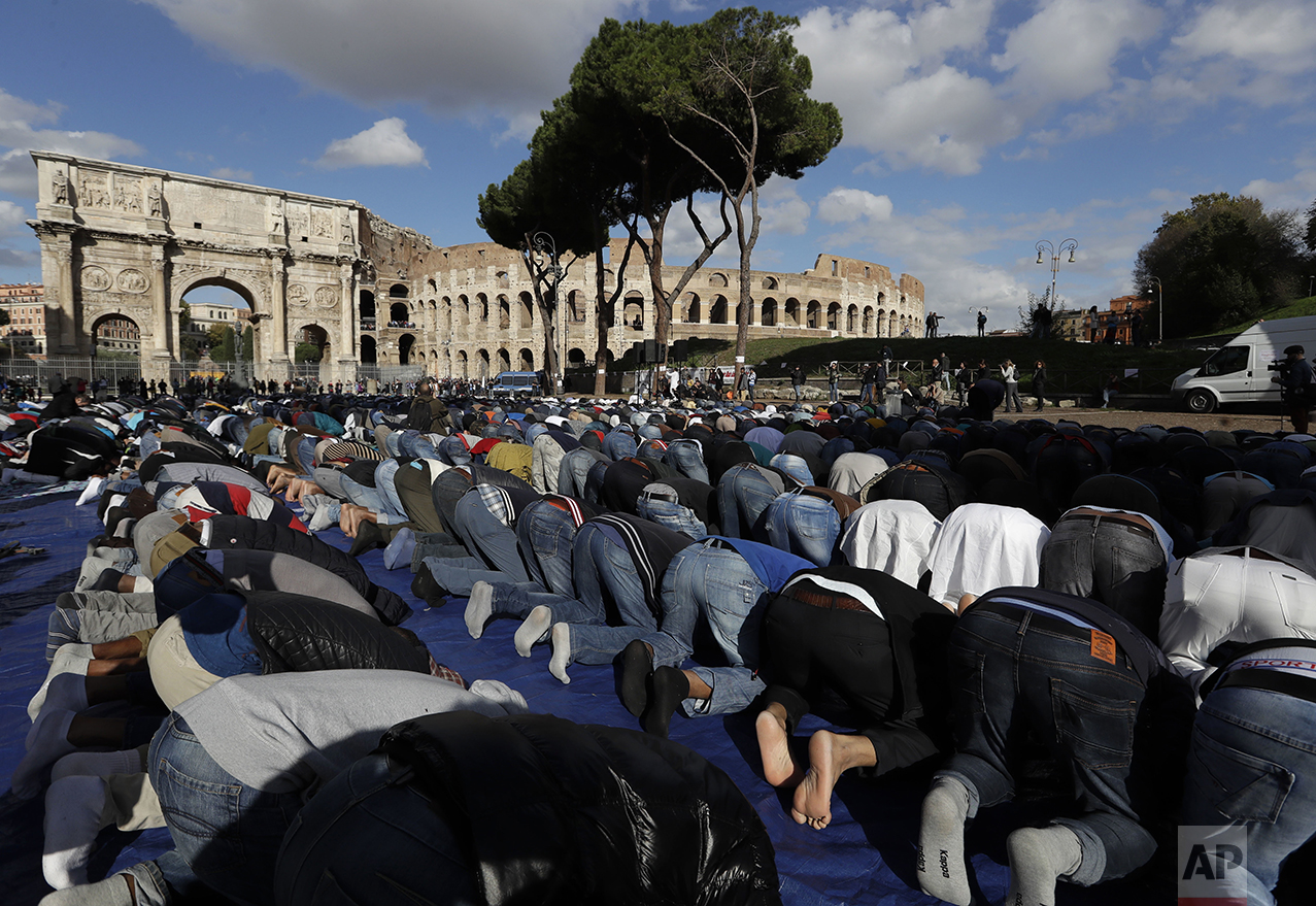 Men attend Friday prayers during a demonstration near Rome's ancient Colosseum on Friday, Oct. 21, 2016. The Muslim community of Rome gathered by the historic landmark to pray and protest the closures of mosques and other places of worship. (AP Photo/Alessandra Tarantino)