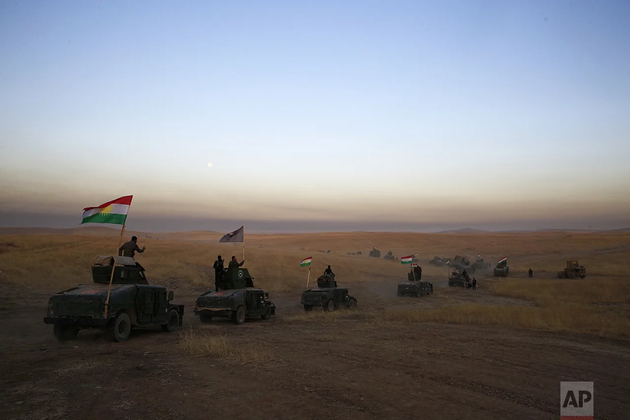 In this Monday, Oct. 17, 2016 photo, Peshmerga convoy drives towards a frontline in Khazer, about 30 kilometers (19 miles) east of Mosul, Iraq. In the week since Iraq launched an operation to retake Mosul from the Islamic State group, its forces have pushed toward the city from the north, east and south, battling the militants in a belt of mostly uninhabited towns and villages. In the heavily mined approaches to the city they met with fierce resistance, as IS unleashed suicide truck bombs, rockets and mortars. (AP Photo/Bram Janssen)